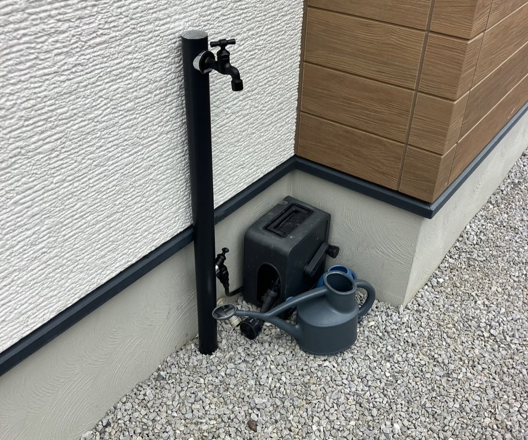 砂利敷きの建物まわりと立水栓
