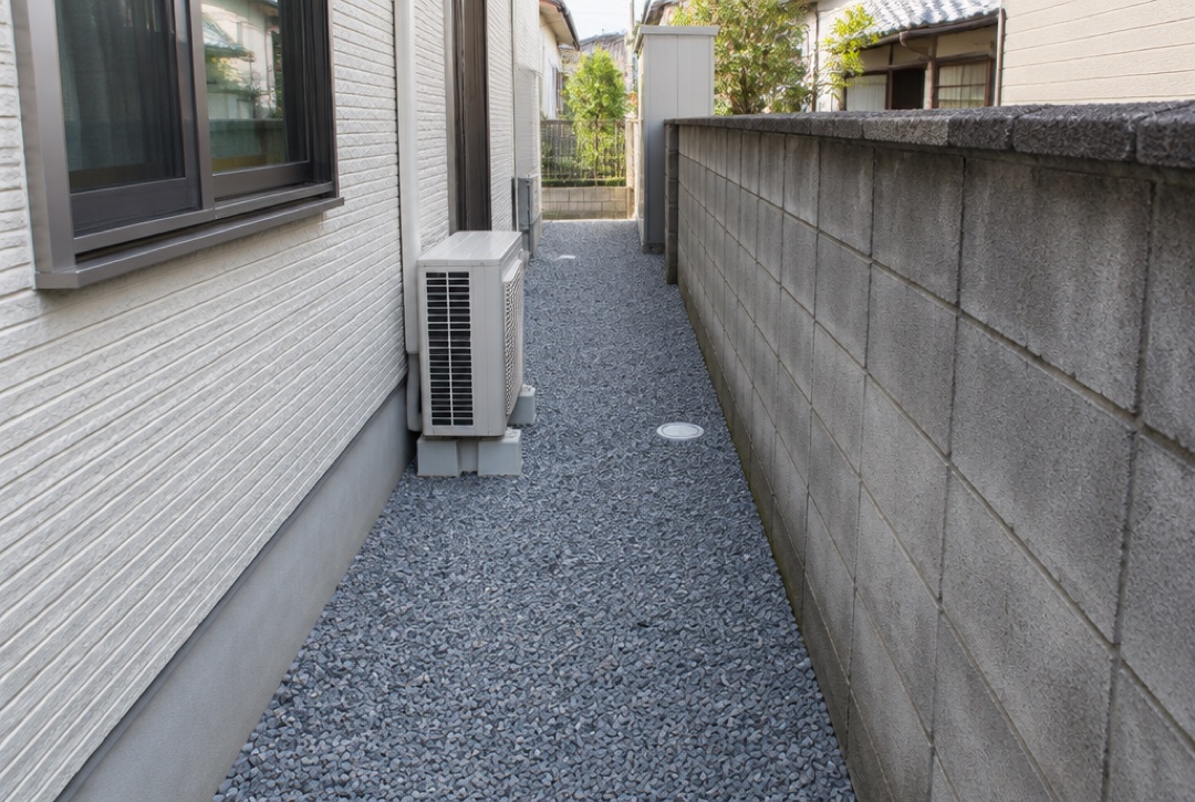 建物の横の通路に防草シートと砂利を敷いた様子