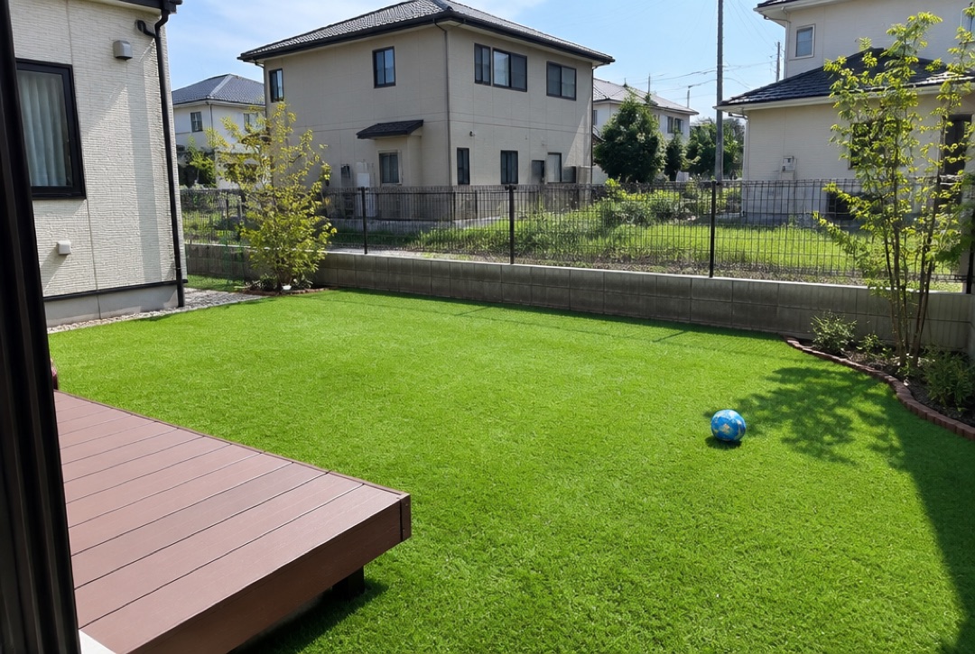 人工芝を敷いた住宅の庭とウッドデッキ